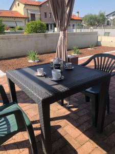 una mesa negra con tazas y platillos. en HOME NUOVA OSTIGLIA, en Padernello