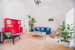 een woonkamer met een blauwe bank en een tafel bij Casa delle Rondini in Presicce