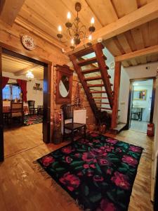 a living room with a chandelier and a rug at Casuta din Cotroape - Maramureș in Săcel