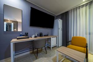 Zimmer mit einem Schreibtisch und einem gelben Stuhl in der Unterkunft Brown Dot Hotel Angang in Gyeongju