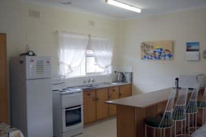 uma cozinha com um frigorífico branco e um lavatório em Comfortable Unit Close to the Beach em Victor Harbor