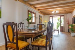 a dining room with a wooden table and chairs at Sa Capella in Santa Margalida