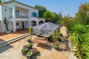 a house with a patio with a table and plants at Sa Capella in Santa Margalida