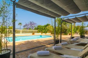 a group of lounge chairs next to a swimming pool at Sa Capella in Santa Margalida