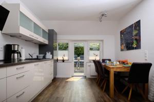 uma cozinha e sala de jantar com mesa e cadeiras em Ferienwohnung Schwarting em Wiefelstede