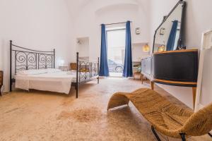 een slaapkamer met een bed en een tv. bij Casa delle Rondini in Presicce
