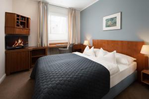 een hotelkamer met een bed en een open haard bij Hotel Baseler Hof in Hamburg