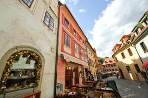 a street with tables and chairs next to a building at Mini Hotel Abraka & Apartments in Český Krumlov