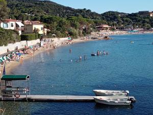 a group of people swimming in the water at a beach at la raganella - appartamento in Procchio