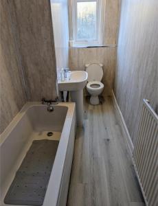 La salle de bains est pourvue d'une baignoire, de toilettes et d'un lavabo. dans l'établissement Cozy Room Close To The City, à Édimbourg