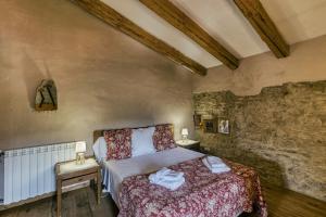 a bedroom with a bed and a stone wall at Casa de Pueblo in Cantallops