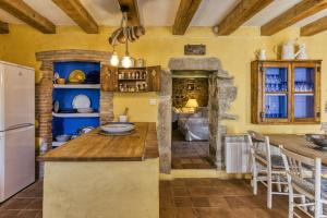 a kitchen with yellow walls and wooden ceilings at Casa de Pueblo in Cantallops