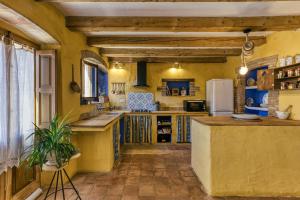 a kitchen with yellow walls and wooden ceilings at Casa de Pueblo in Cantallops +24 photos