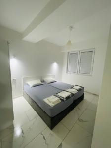 - une chambre blanche avec un lit dans l'établissement Skopje Boutique Apartments, à Skopje