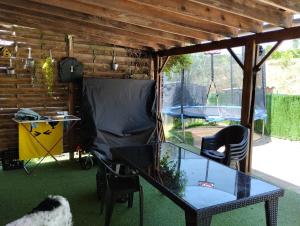 a patio with a glass table and a trampoline at Maison Les Cigales in Leuc