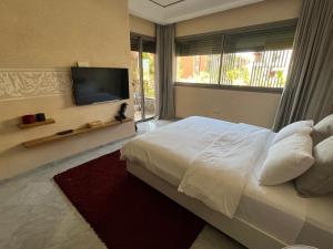 um quarto com uma cama grande e uma televisão em Marrakech M Avenue CR 7 appart terrasse em Marraquexe