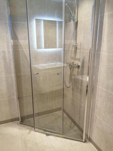 um chuveiro com uma porta de vidro na casa de banho em Himahuset em Tysvær
