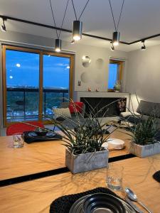 a living room with a wooden table with potted plants at Aggi - Apartament Premium z widokiem na morze - AZW Gdańsk in Gdańsk +75 photos