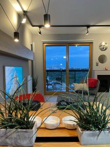 a living room with a table with potted plants at Aggi - Apartament Premium z widokiem na morze - AZW Gdańsk in Gdańsk