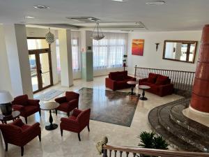 a lobby with red chairs and tables in a building at Perla Marina in Nerja
