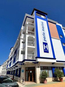 a white and blue building with a car parked in front at Perla Marina in Nerja