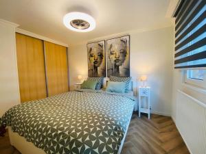 1 dormitorio con 1 cama grande y una pintura en la pared en Ferienhaus LuxChalet VAJU IJsselView direkt am Fluss See Pool Park en Lathum