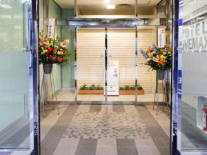 an entrance to a building with flowers on the door at HOTEL LiVEMAX BUDGET Hamamatsu-Ekimae in Hamamatsu