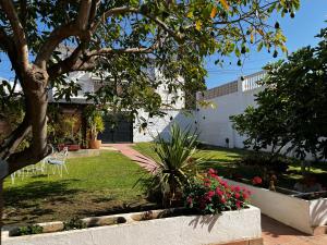 a garden with a tree and flowers in a yard at Bonito chalet en La Cala con gran jardín privado in Cala del Moral