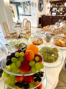 a table topped with plates of fruit and pastries at Hotel Sylesia in Letojanni