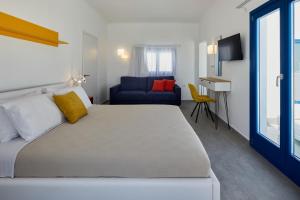 a bedroom with a large bed and a blue couch at Thadeos Villa with private jetted Pool in Fira +41 photos