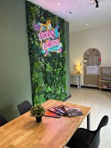 um restaurante com uma parede verde com um cartaz em Swing & Pillows @ Malabar em George Town