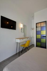 a room with a desk and a yellow chair at Thadeos Villa with private jetted Pool in Fira