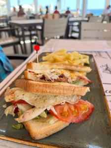 two sandwiches on a plate with chips on a table at Perla Marina in Nerja