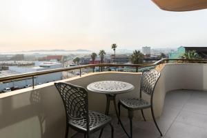 a table and chairs on a balcony with a view at Urban Artisan Luxury Suites by Totalstay in Cape Town