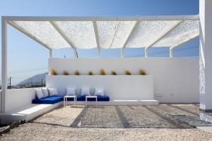 a room with two blue chairs and a table at Thadeos Villa with private jetted Pool in Fira