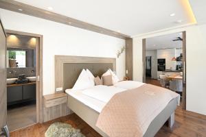 シュラートミンクにあるAppartment Sun Chaletのベッドルーム(大きな白いベッド1台付)、キッチンが備わります。