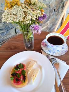 un plato con un sándwich en una mesa con una taza de café en Hotel Kepney en Omalo