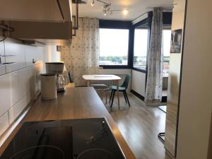 eine Küche mit einer Theke und einem Tisch mit Stühlen in der Unterkunft Wohnung DC 13A in Neu Ulm