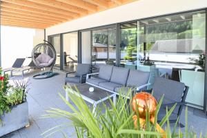 a patio with chairs and a couch and a table at Appartment Sun Chalet in Schladming