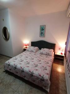 sypialnia z łóżkiem i dwoma stołami z lampkami w obiekcie Guest House Bа́kish Obzor w Obzorze