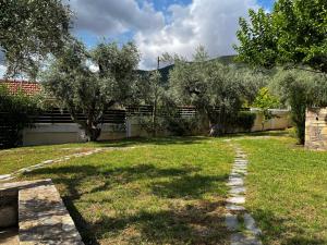 a yard with a fence and trees and a path at Villa Liana in Soúrpi