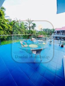 a pool with chairs and tables on a balcony at Danial Homestay Semporna in Semporna