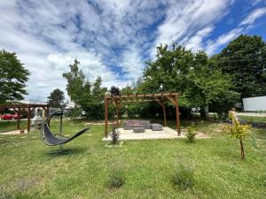 a park with a bench in the grass at Levendulakert Siófok Apartmanház in Siófok