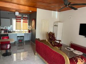 a living room with a couch and a kitchen at Yazmin Studio Residence in Lamin