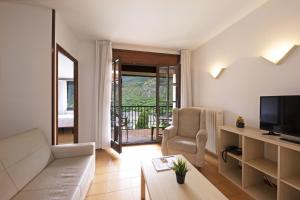 un soggiorno con un divano e una televisione di La Solana Apartaments & Spa a Encamp