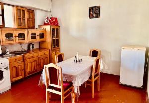 a kitchen with a table with chairs and a refrigerator at Ismayilli Bag Evi, Vacation Home in İsmayıllı