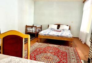 1 dormitorio con 1 cama y 1 alfombra en una habitación en Ismayilli Bag Evi, Vacation Home, en İsmayıllı