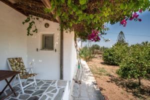 a white house with a window and a table and chairs at Green Retreats 3 Paros in Isterni +13 photos