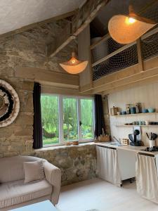 a kitchen and living room with a stone wall at La Passerelle in Loguivy-Plougras