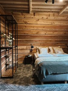 a bedroom with a wooden wall with a bed at Dom Górski 878 mnpm in Zakopane